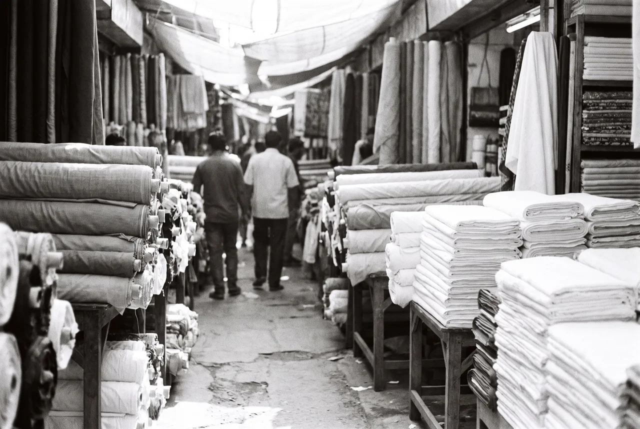 Stimmungsbild: Stapel heller Stoffe auf einem Markt